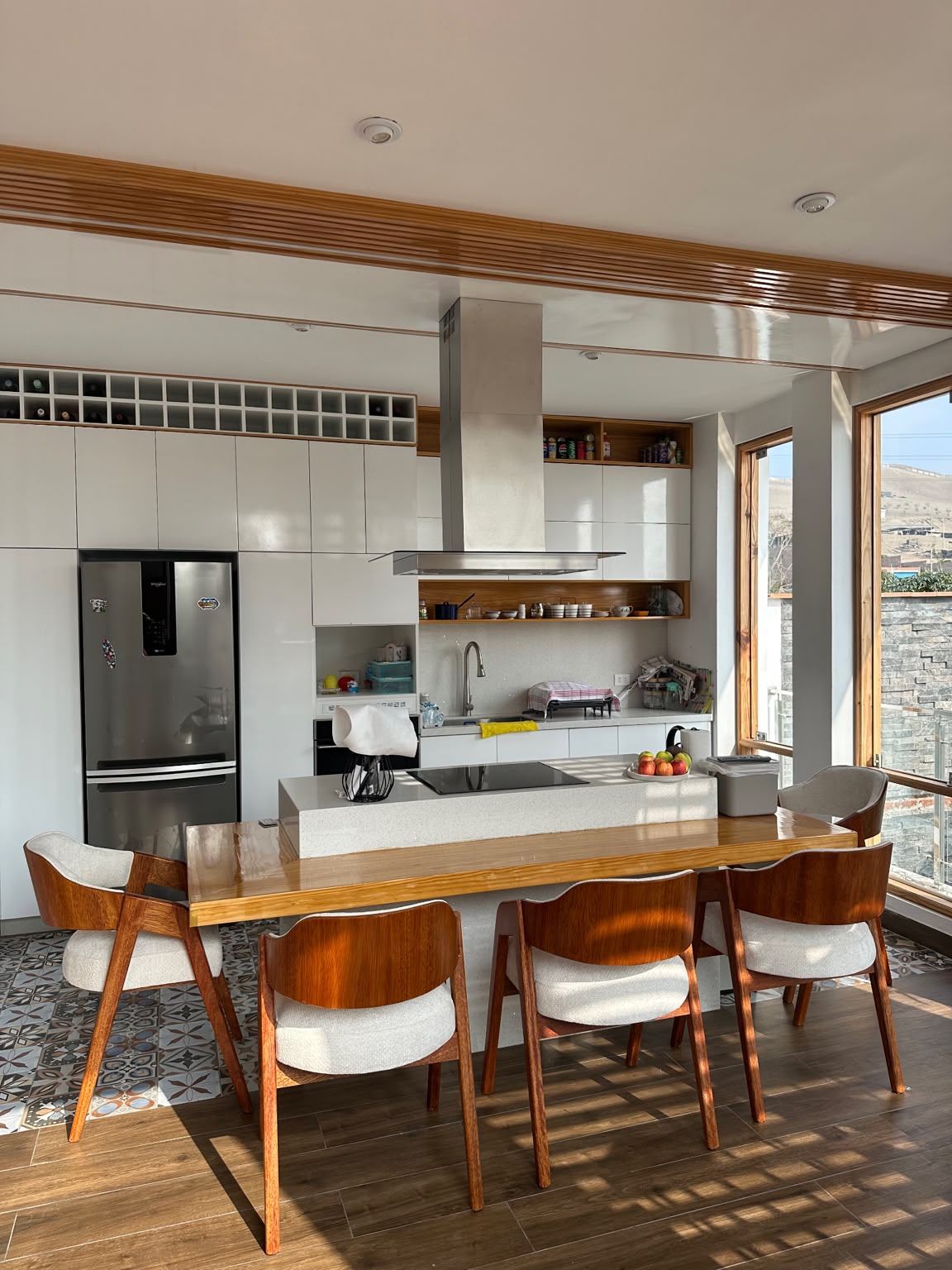Diseño de cocina — Isla y mesa en madera: cocinar y compartir frente al paisaje.